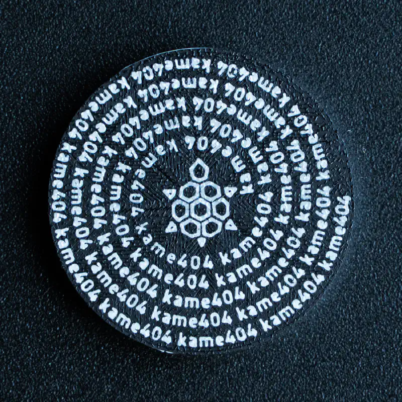 裏面のデザイン全体。黒背景に白文字がらせん状に配置され、中心にロゴがある